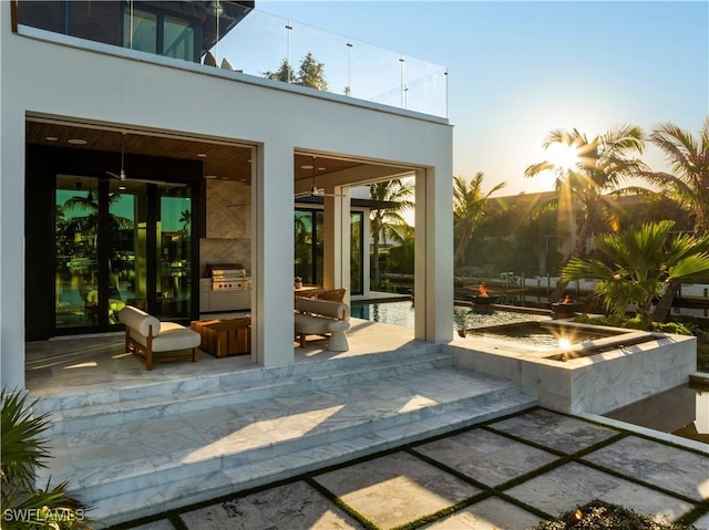 patio terrace at dusk featuring a fire pit