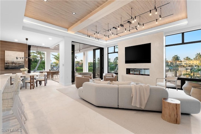 living area featuring healthy amount of natural light, a tray ceiling, and recessed lighting