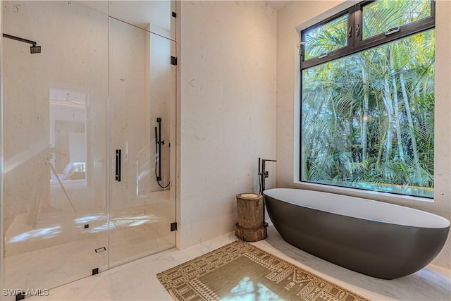 full bath featuring a soaking tub and a shower stall