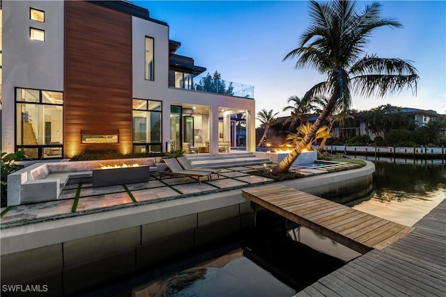 back of house featuring a fire pit, a balcony, and a patio area