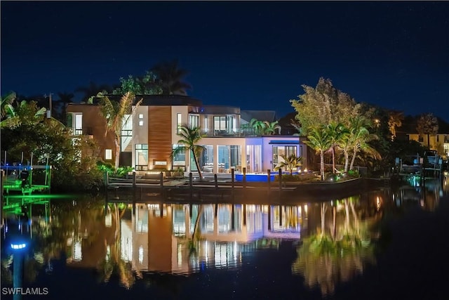back of house at twilight with a water view