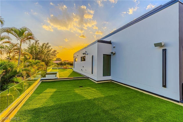 back of property featuring stucco siding and a lawn