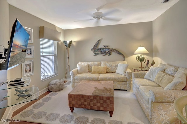 living room featuring visible vents, baseboards, and a ceiling fan