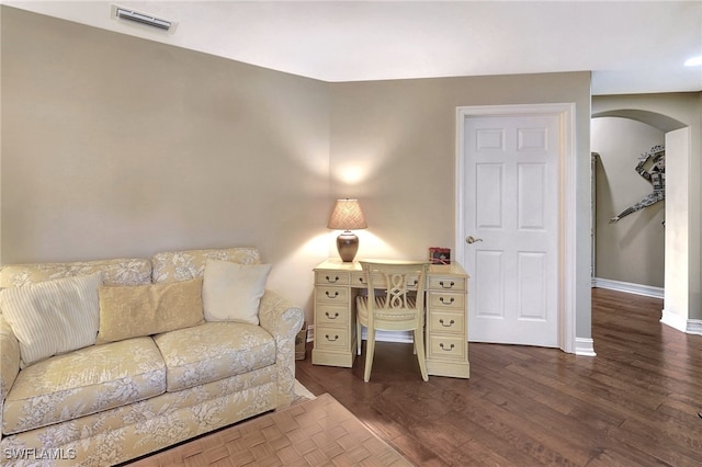 living room with arched walkways, visible vents, dark wood-type flooring, and baseboards