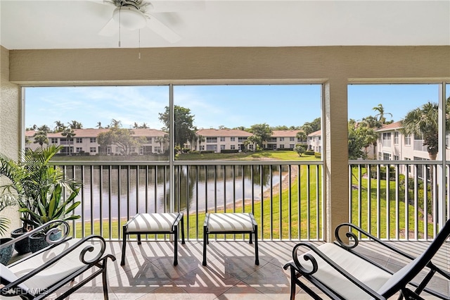 sunroom featuring a residential view, plenty of natural light, and a water view