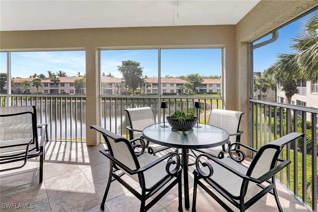 sunroom featuring a water view