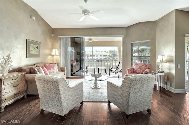 living room featuring baseboards, a ceiling fan, and dark wood-style flooring