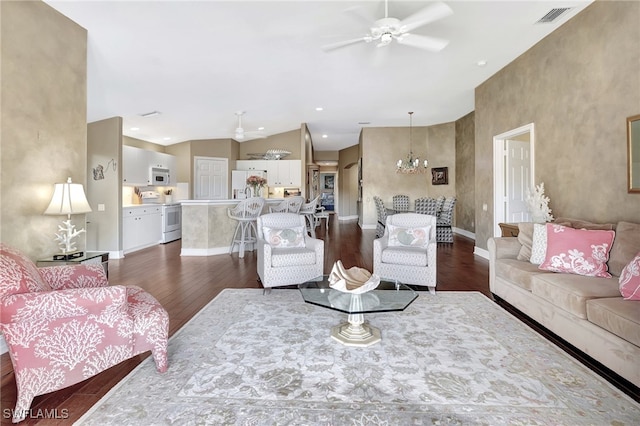 living room featuring ceiling fan with notable chandelier, dark hardwood / wood-style flooring, and lofted ceiling