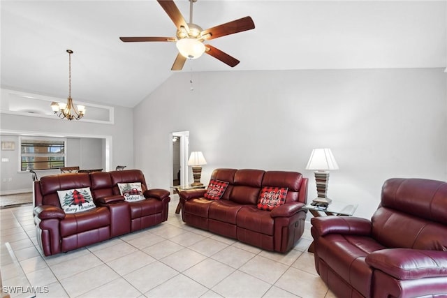 tiled living room with ceiling fan with notable chandelier and vaulted ceiling