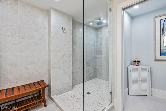 bathroom with a tile shower and tile patterned flooring