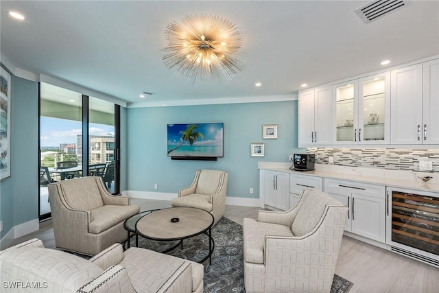 living room with light wood-type flooring, indoor bar, wine cooler, and a wall of windows