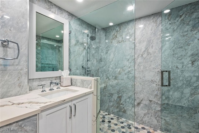 bathroom featuring vanity, walk in shower, and tile walls