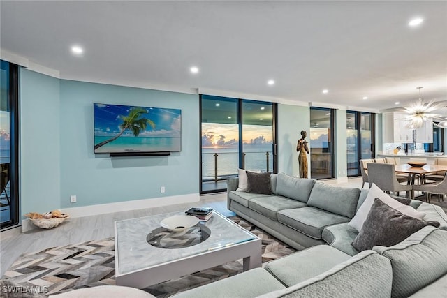 living room featuring light wood-type flooring, expansive windows, and a notable chandelier