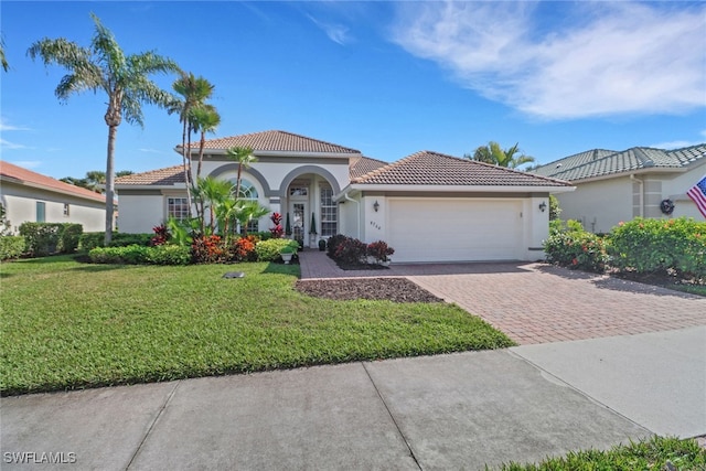 mediterranean / spanish house featuring a front yard and a garage