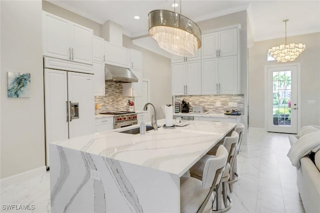 kitchen featuring sink, a center island with sink, a chandelier, white cabinetry, and hanging light fixtures