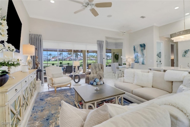 living room with ceiling fan with notable chandelier and light tile patterned floors