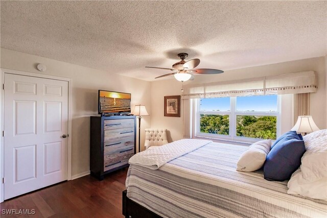 bedroom featuring a textured ceiling, ceiling fan, and dark wood-type flooring