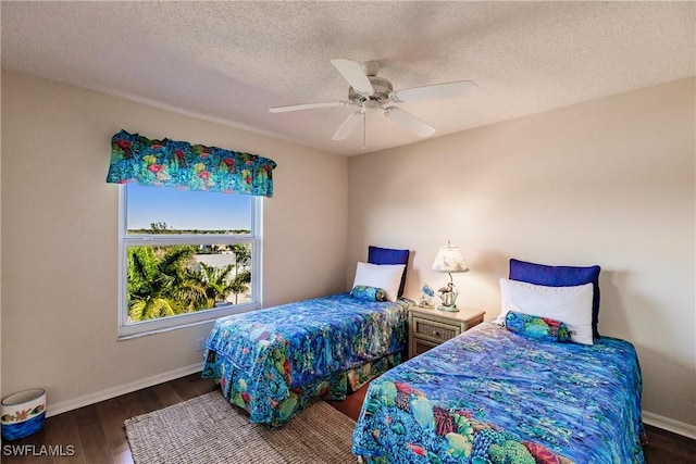 bedroom featuring dark hardwood / wood-style flooring, a textured ceiling, and ceiling fan