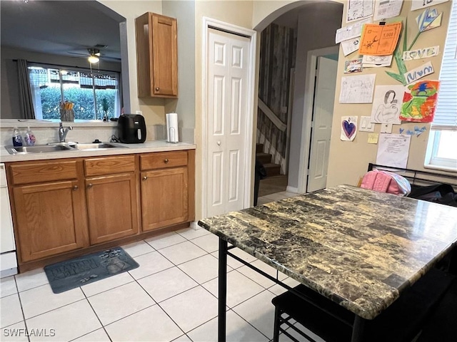 kitchen featuring ceiling fan, a healthy amount of sunlight, light tile patterned flooring, and sink