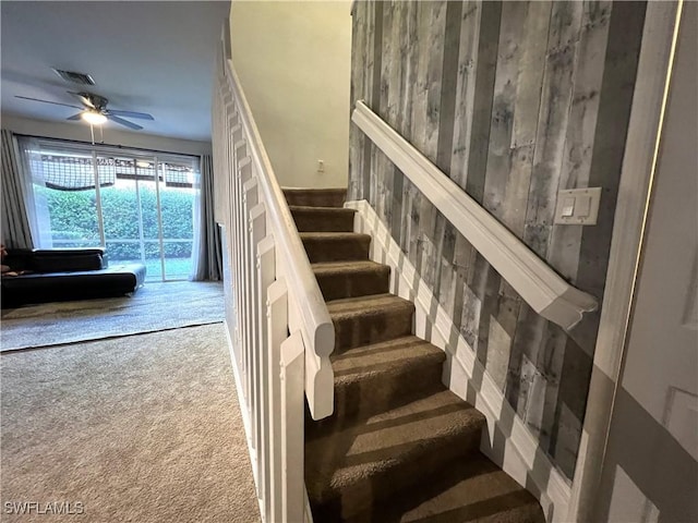 stairway with carpet flooring and ceiling fan