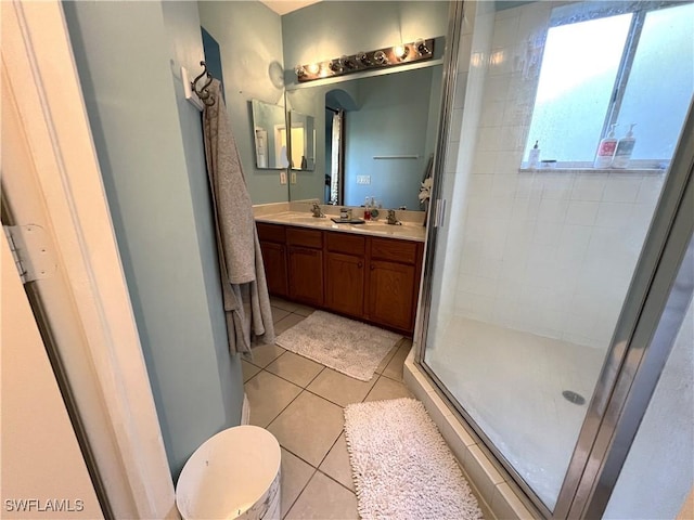 bathroom featuring tile patterned flooring, vanity, and a shower with door