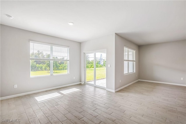 unfurnished room featuring a healthy amount of sunlight and light hardwood / wood-style floors