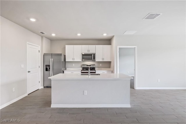 kitchen featuring a center island with sink, white cabinets, stainless steel appliances, and sink