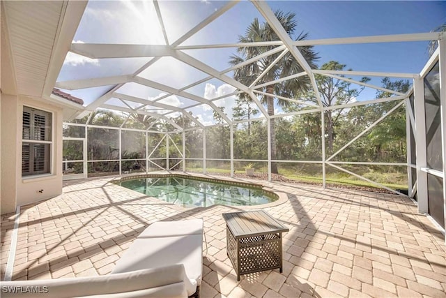 view of swimming pool featuring a patio area and glass enclosure