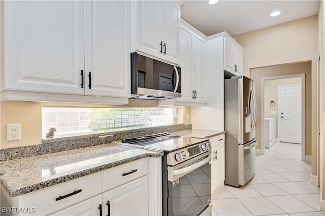 kitchen with appliances with stainless steel finishes, light tile patterned floors, stone countertops, and white cabinetry