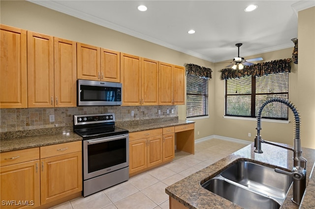 kitchen featuring light tile patterned flooring, stainless steel appliances, crown molding, and sink