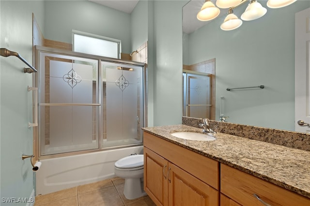 full bathroom with tile patterned floors, vanity, toilet, and bath / shower combo with glass door