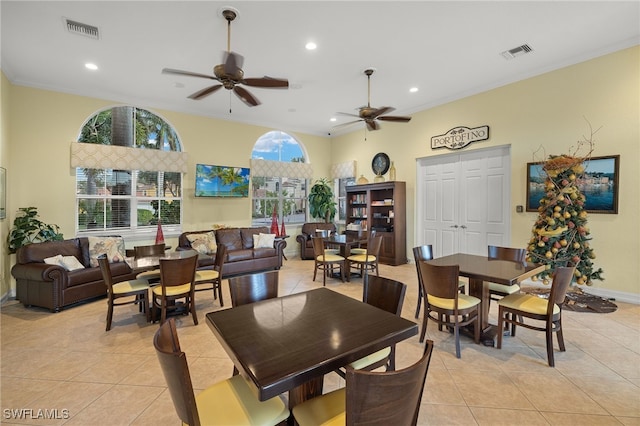 dining area featuring ceiling fan, crown molding, and light tile patterned floors