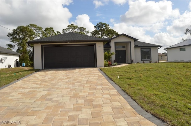 view of front of property featuring a front yard and a garage