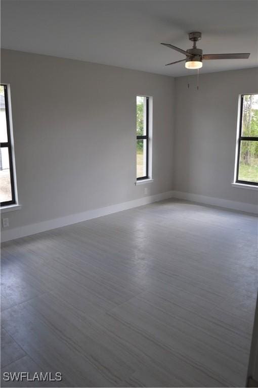 unfurnished room featuring plenty of natural light, ceiling fan, and wood-type flooring