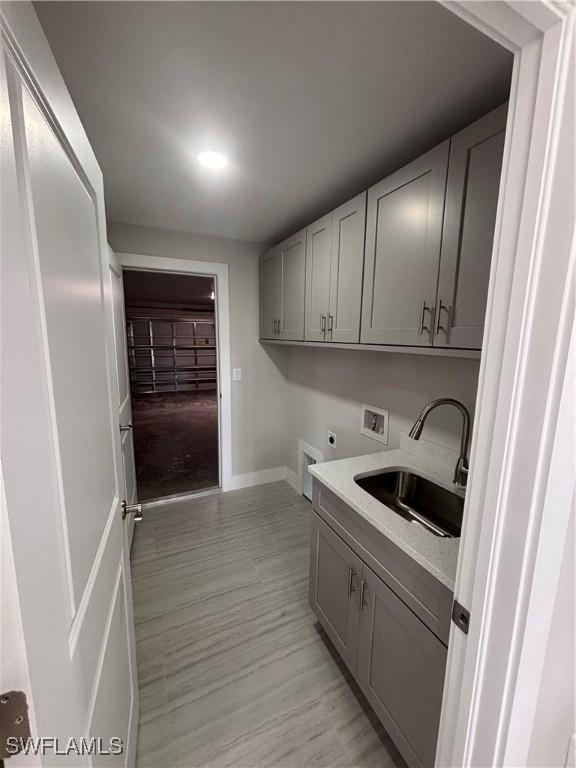 laundry room featuring hookup for an electric dryer, cabinets, sink, and hookup for a washing machine