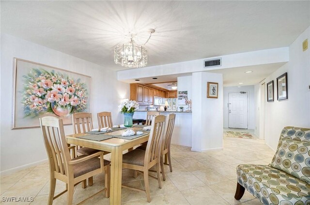 tiled dining space featuring an inviting chandelier