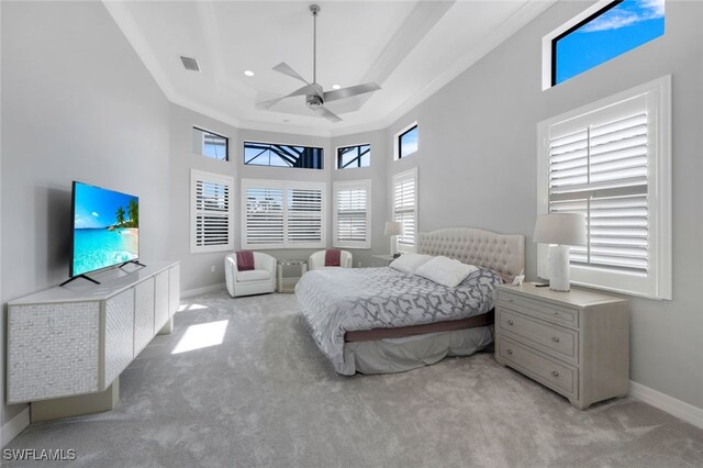 carpeted bedroom featuring ceiling fan, a towering ceiling, ornamental molding, and multiple windows