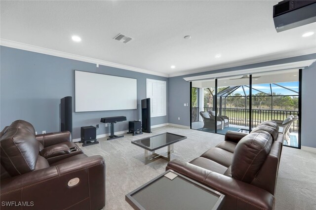 home theater with crown molding and light carpet