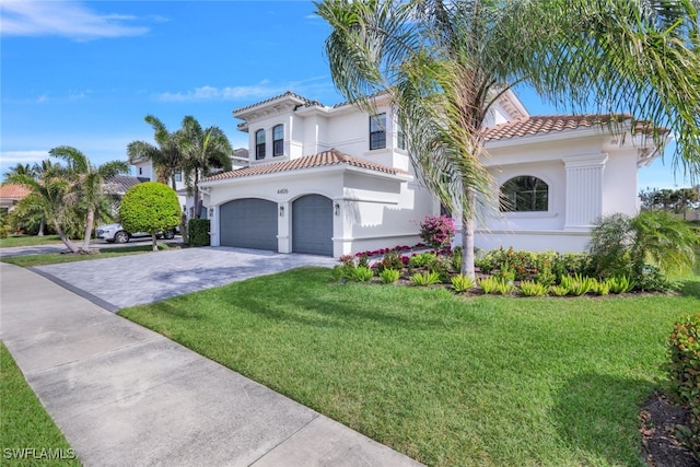 mediterranean / spanish house with a garage and a front lawn