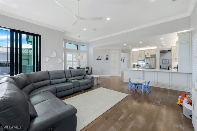 living room featuring dark hardwood / wood-style floors, ceiling fan, and crown molding