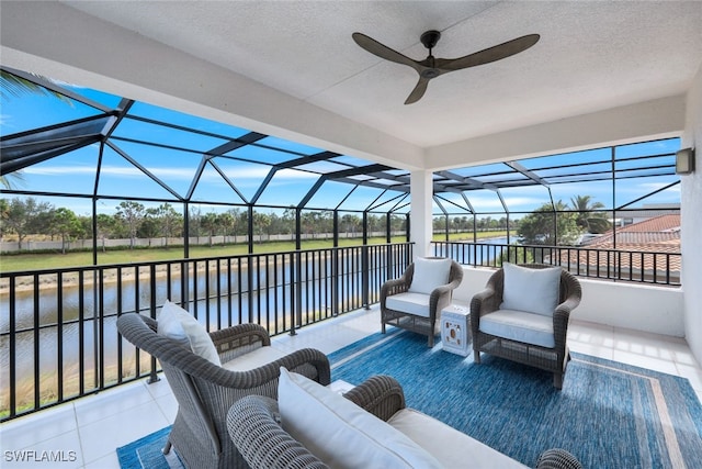 view of patio / terrace featuring outdoor lounge area, a water view, glass enclosure, and ceiling fan