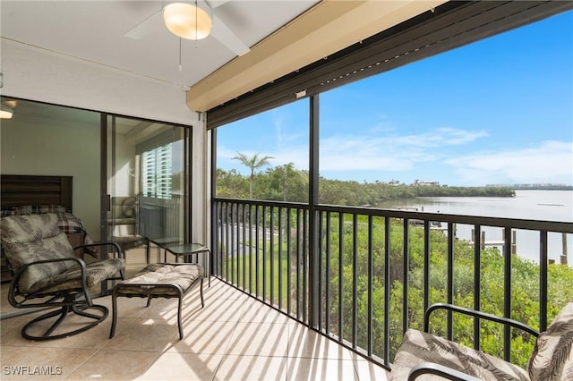 sunroom / solarium with ceiling fan, a water view, and a wealth of natural light