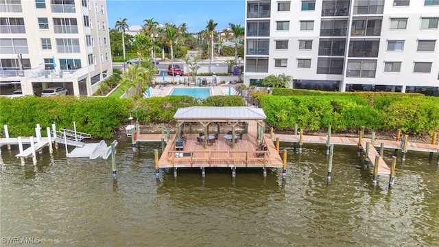 view of dock featuring a gazebo, a community pool, and a water view