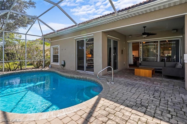 pool featuring glass enclosure, a patio area, ceiling fan, and outdoor lounge area