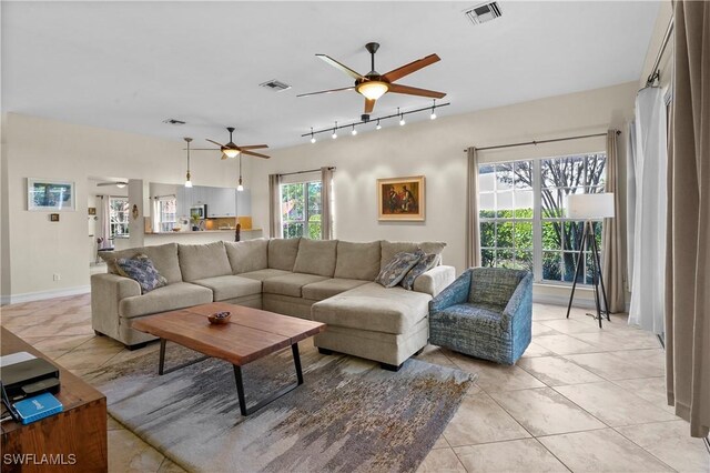 living area featuring light tile patterned floors, ceiling fan, and visible vents