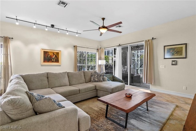 living area featuring baseboards, a ceiling fan, visible vents, and tile patterned floors