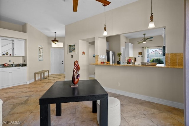 dining space with light tile patterned floors, a ceiling fan, and baseboards