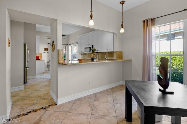 kitchen featuring white cabinetry, baseboards, appliances with stainless steel finishes, tasteful backsplash, and decorative light fixtures