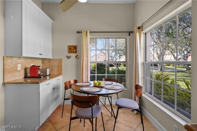 dining room with light tile patterned floors and baseboards