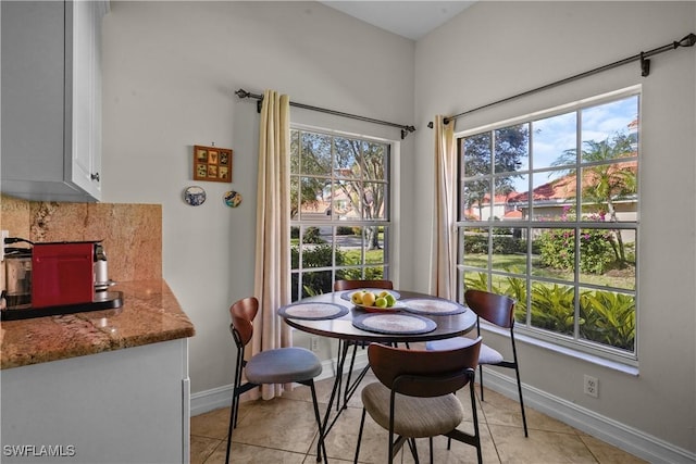 dining space featuring baseboards, light tile patterned floors, and a healthy amount of sunlight